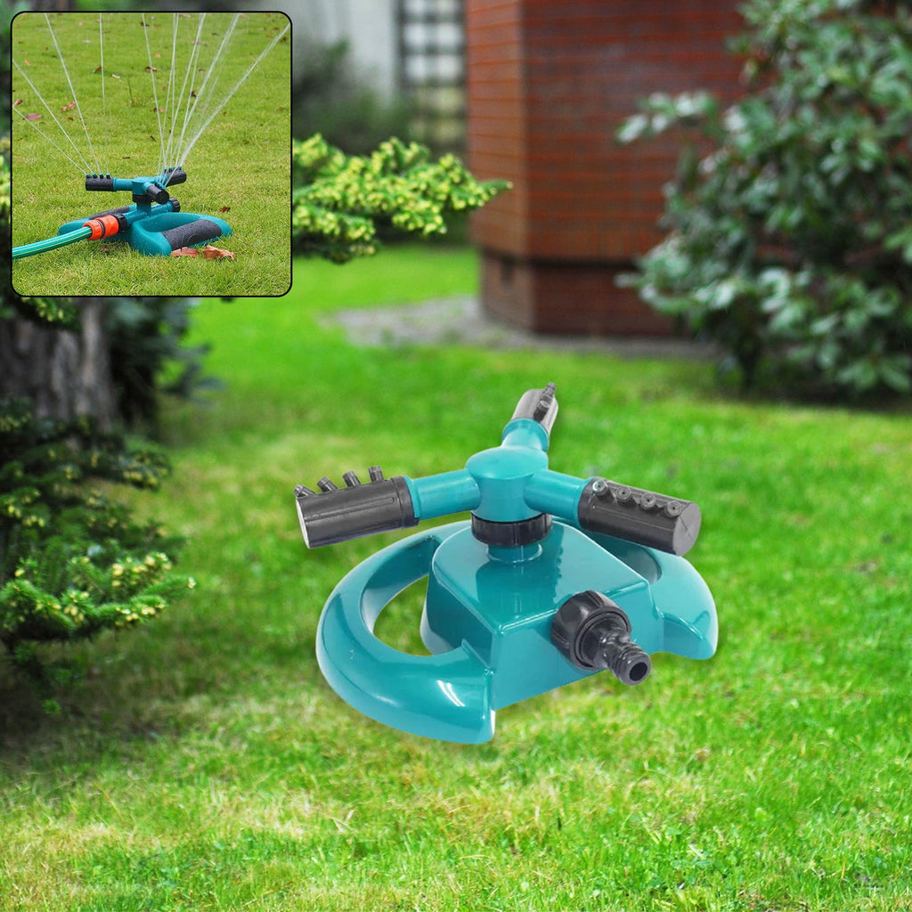 A 3-arm rotating garden sprinkler positioned on green grass.