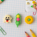 Collection of cute cartoon erasers in various 3D shapes like ghost, pea pod, and pumpkin.