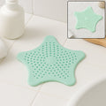 Mint green silicone star shaped sink strainer placed on bathroom sink drain
