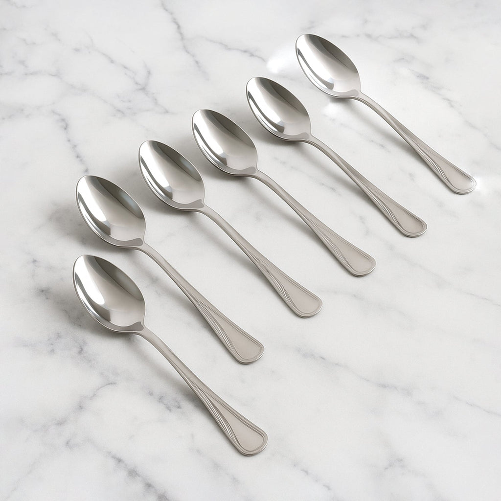 Set of 6 stainless steel dining spoons with polished finish on dining table