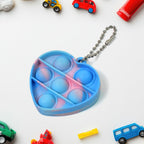 Assortment of colorful mini fidget keychains, showcasing various pop bubble designs attached to keys.