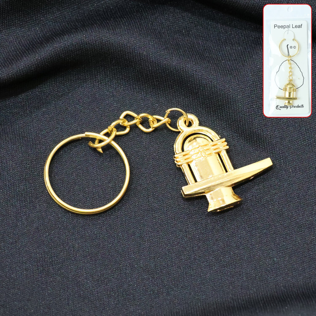 Golden Shivling metal keychain displayed on white background symbolizing spiritual devotion