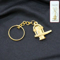 Golden Shivling metal keychain displayed on white background symbolizing spiritual devotion