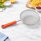 Compact fine mesh kitchen strainer featuring a strong handle