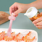 Close-up of the transparent glass oil dispenser and flexible silicone brush head.