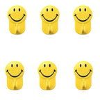 Close-up of a plastic smiley face hook demonstrating its self-adhesive backing.