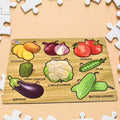 Wooden vegetable puzzle board with colorful carrot, mushroom, and broccoli pieces.