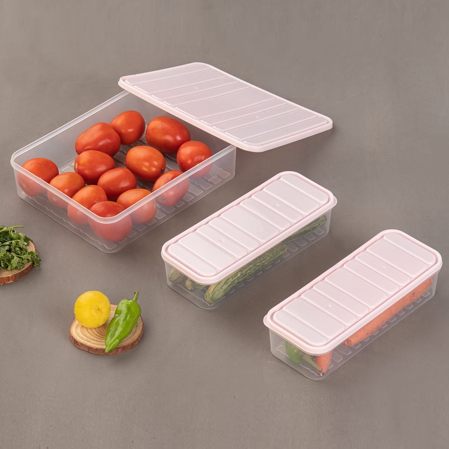 Three clear plastic food storage containers with blue lids, showcasing their stackable design on a kitchen counter.