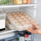 Empty clear plastic egg storage container with its lid placed beside