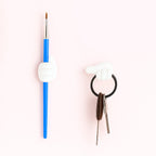 White multifunctional hand-shaped wall clip organizing various small items
