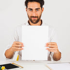A4 copier paper stack on wooden desk with office supplies