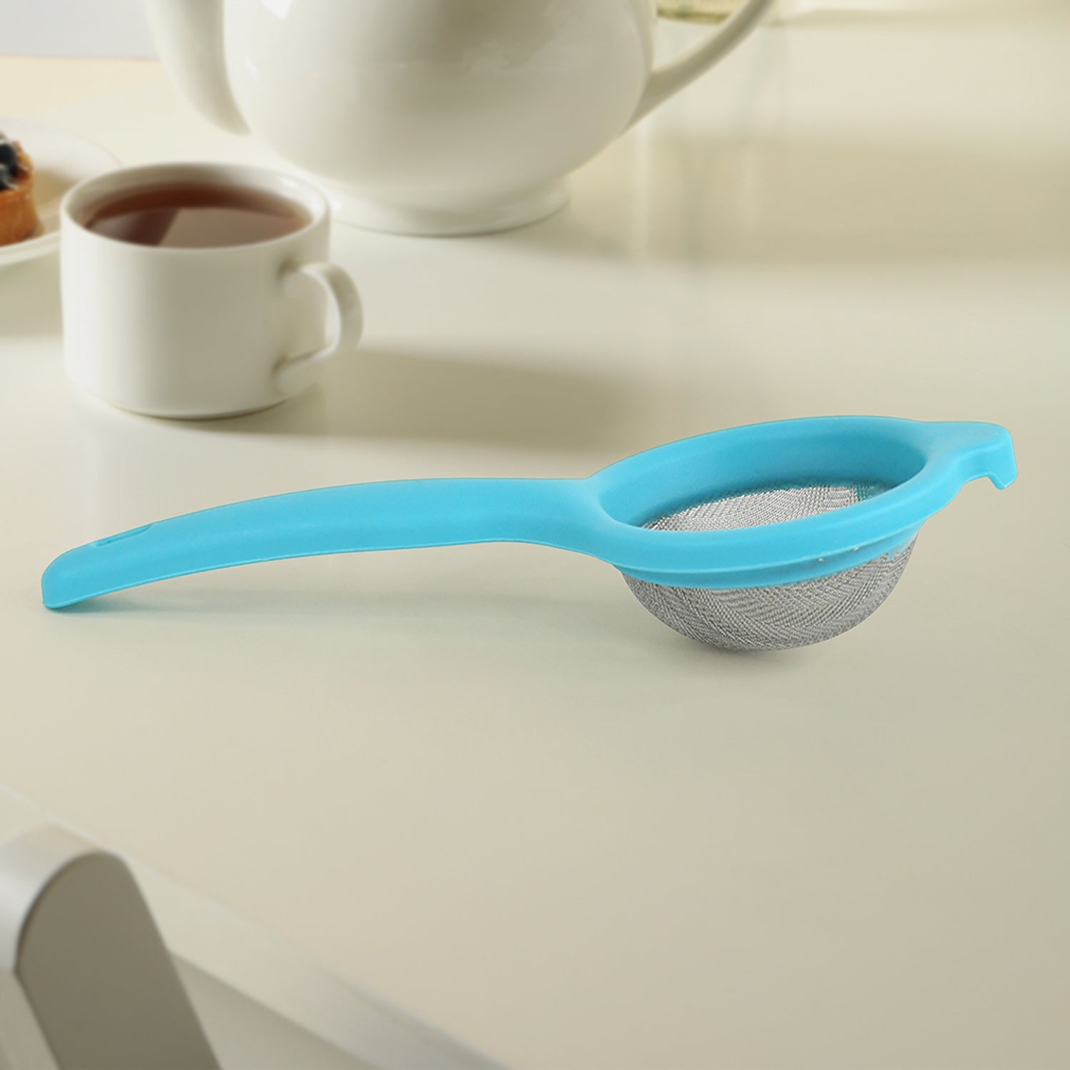 Kadak stainless steel mesh tea strainer with plastic handle on white background