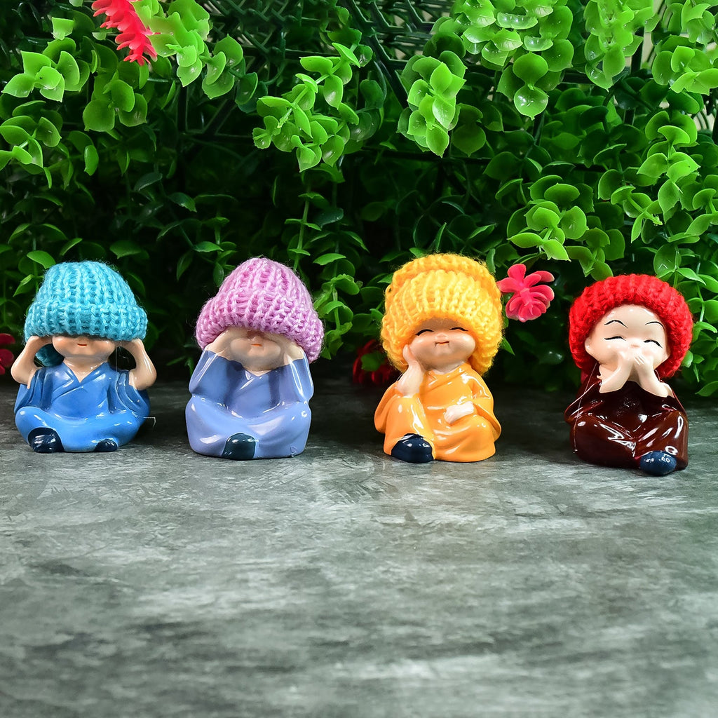 Close-up of resin monk Buddha figurines showing hand-painted details and serene expressions