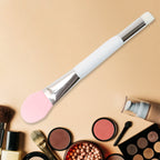 Hand holding silicone applicator brush for facial mask application