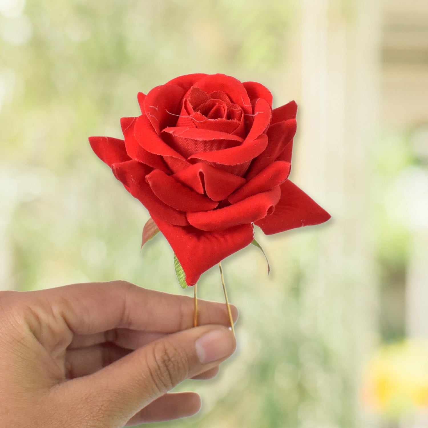 Model wearing multiple red rose hair pins, styled elegantly for a special occasion.
