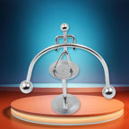 The Mini Steel Balance Toy in motion, demonstrating its perpetual swing on a desk.