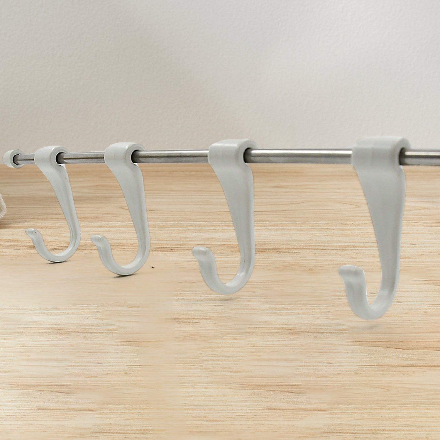 Side view of the sleek stainless steel kitchen utensil hanger with its six sliding hooks.