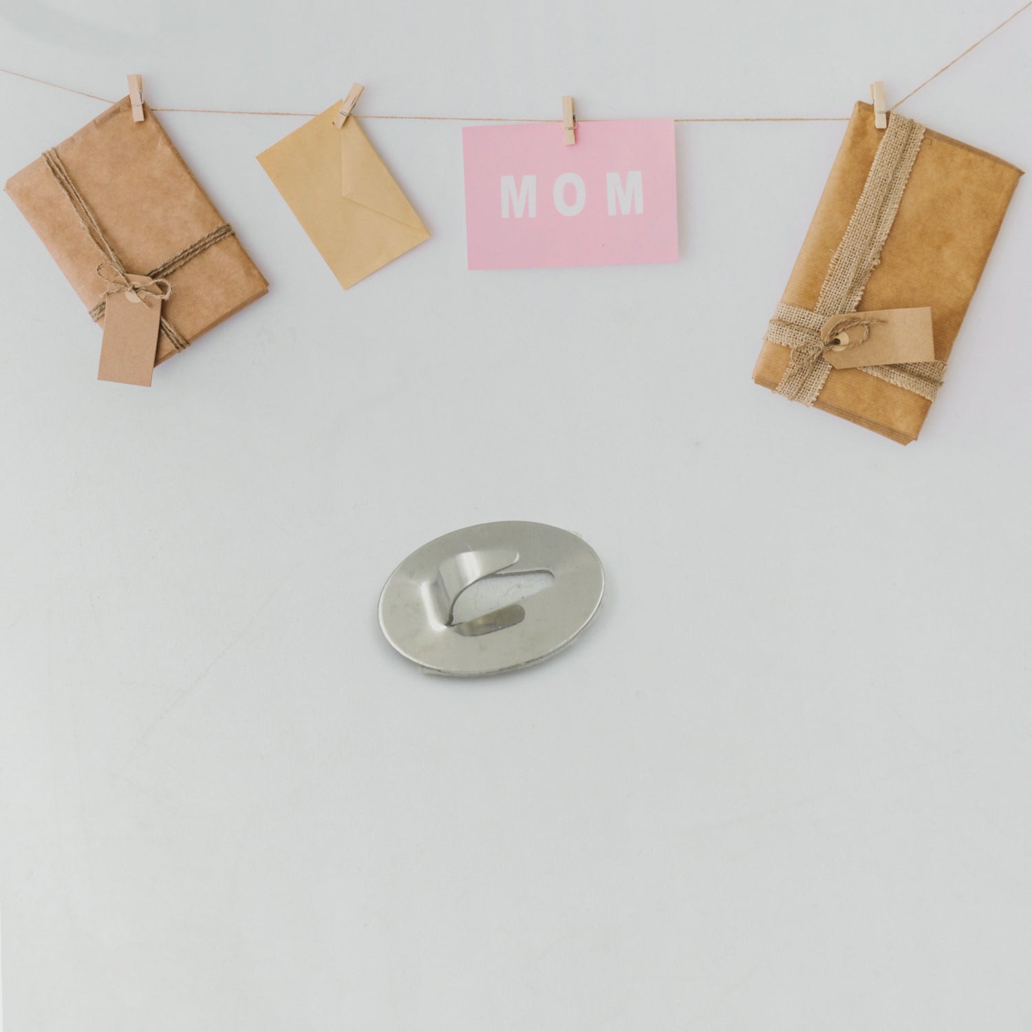 Multiple small stainless steel wall hooks displayed in a stylish arrangement.