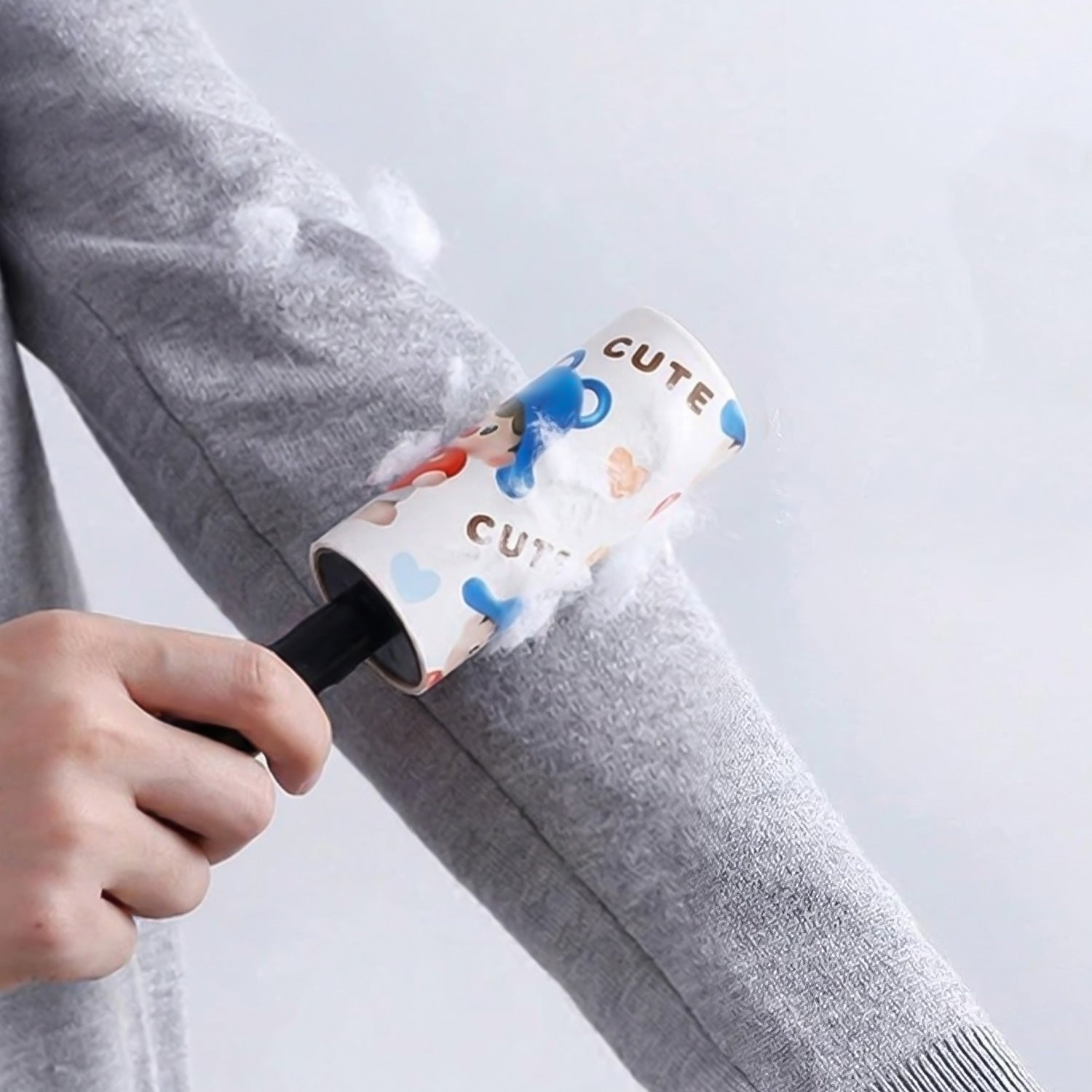 Dust remover lint roller cleaning pet hair from a fabric sofa