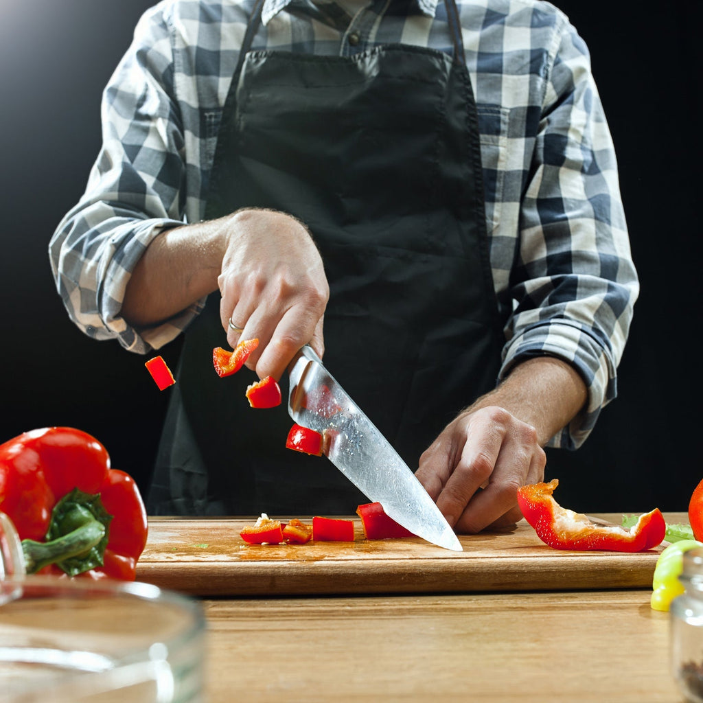 Reversible wooden slicing board with a prominent handle for easy grip.