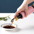 Vastate 300ml olive oil dispenser with a non-drip spout, shown against a clean kitchen background.