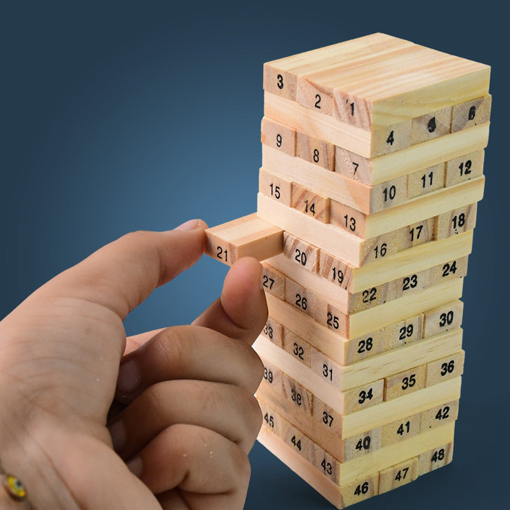 Hands carefully removing a block from the tumbling tower, demonstrating the focus required for the Wooden Stacking Game.