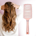 Massage hair comb placed on wooden surface highlighting ergonomic grip