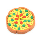 A child's hand holding a bright pizza slice eraser, ready for schoolwork.