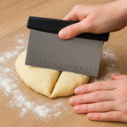 Angled view of dough scraper highlighting stainless steel blade and comfortable handle