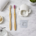 Wall mounted toothbrush holder set with bamboo toothbrushes in bathroom
