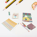 Vibrant cartoon stationery box with a notebook, pen, and eraser for school kids.