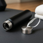 Matte black stainless steel water bottle with secure screw-top lid and strap
