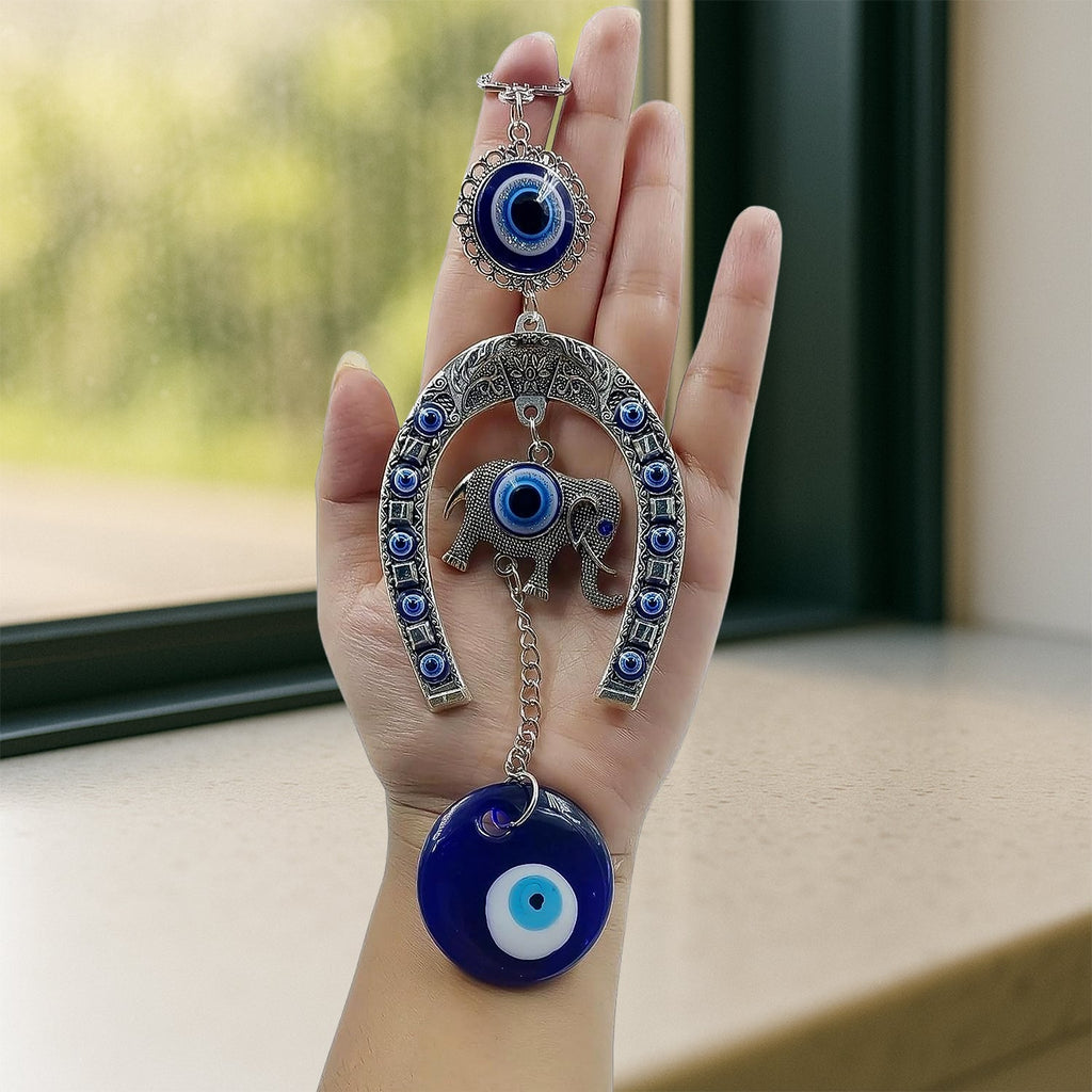 Close-up of alloy metal evil eye hanging with chain and elephant motif