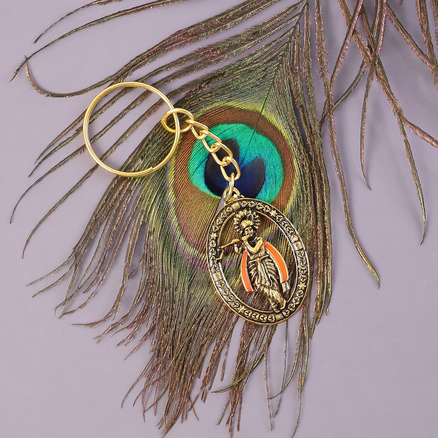 Hand holding Lord Krishna metal keychain showing its size and detail