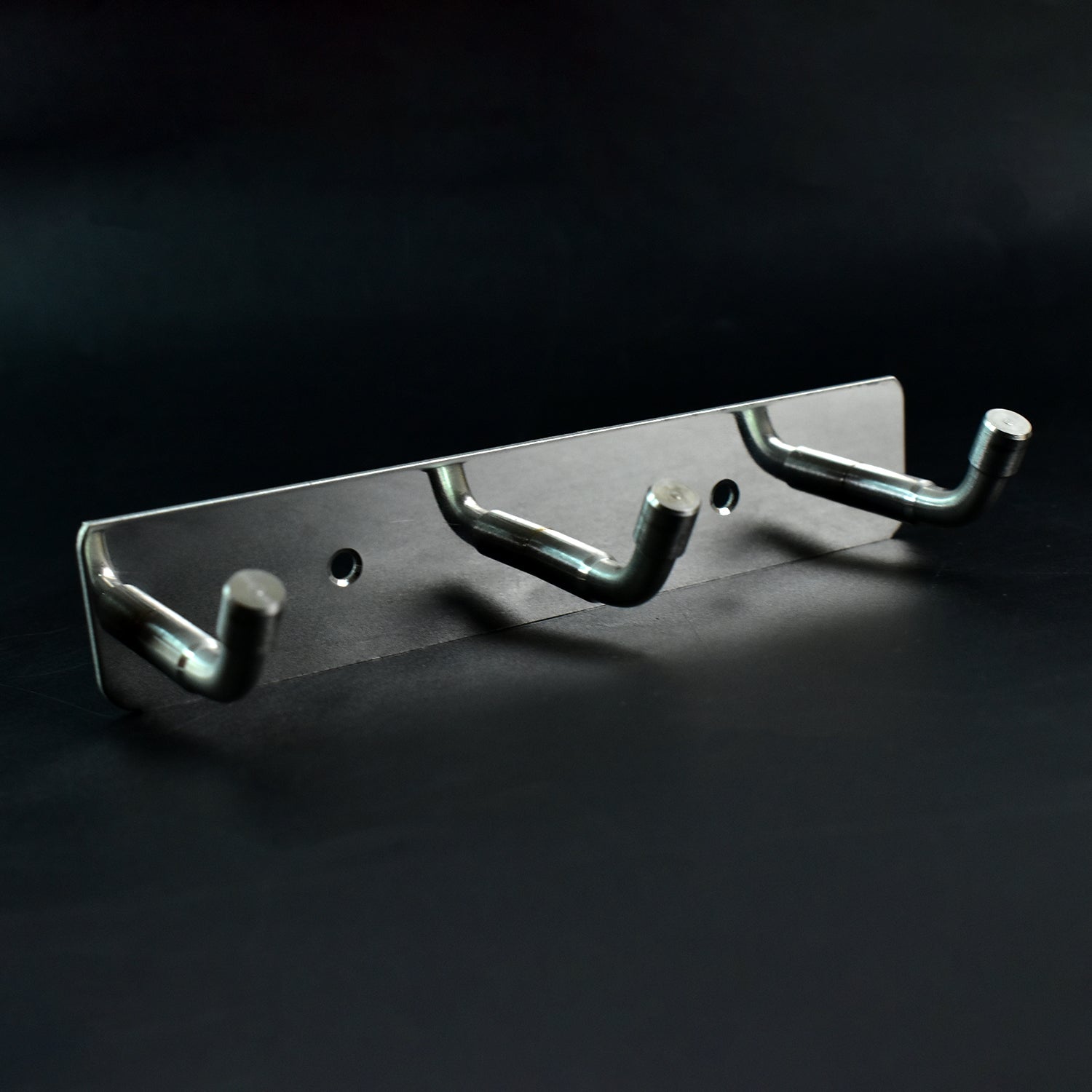 Polished metallic 3 hook rack mounted on bedroom wall