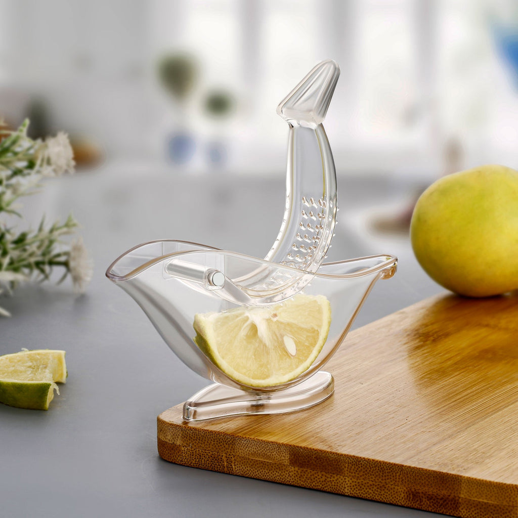 Hand holding the unique bird-shaped manual juicer over a glass.