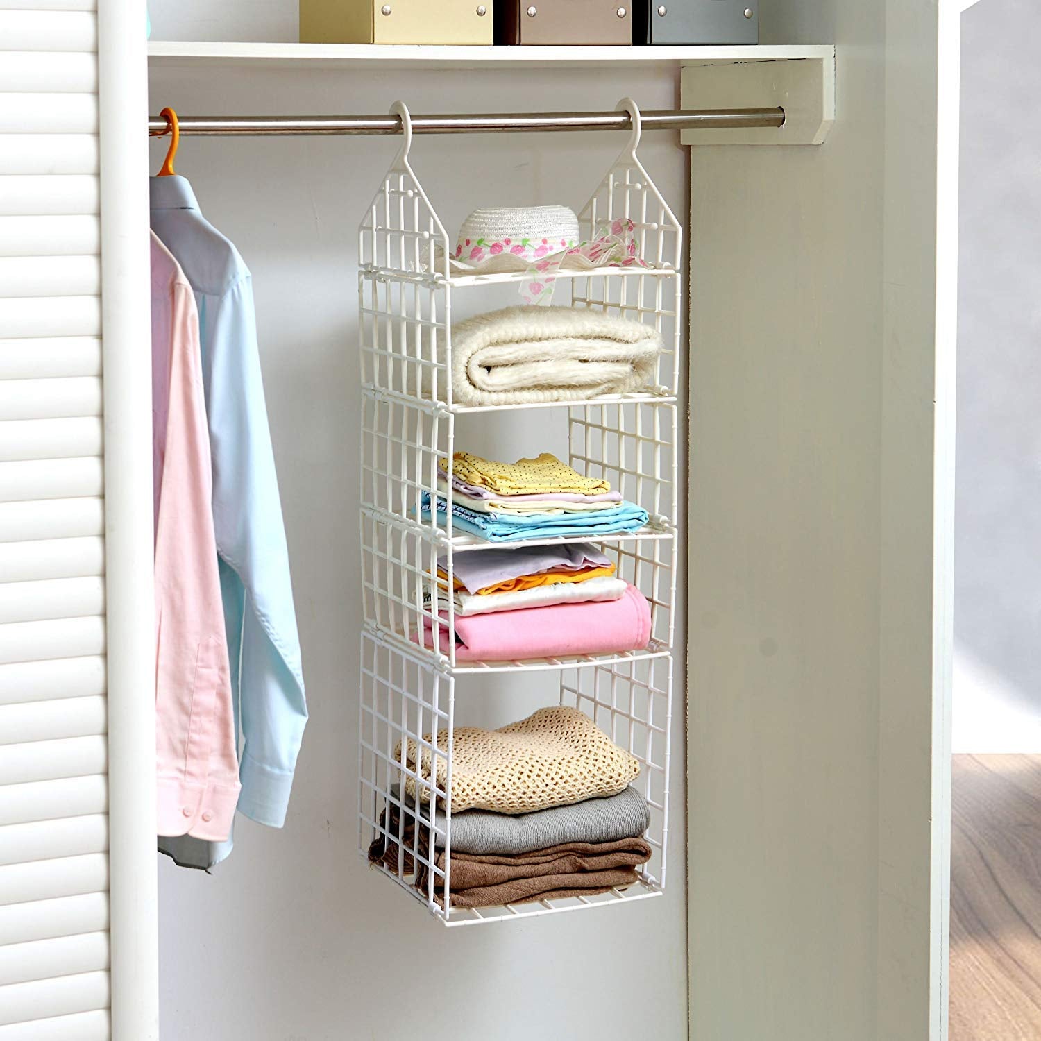 Various clothes, including pants and shirts, neatly hung on the different tiers of the folding clothes hanger.