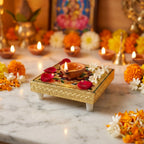 A traditional wooden chowki serving as an altar for a small idol of Ganesha and other pooja essentials.