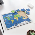 Completed wooden world map puzzle showing continents, animals, and landmarks.
