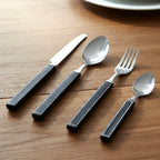 Set of polished stainless steel cutlery with plastic handles for home dining