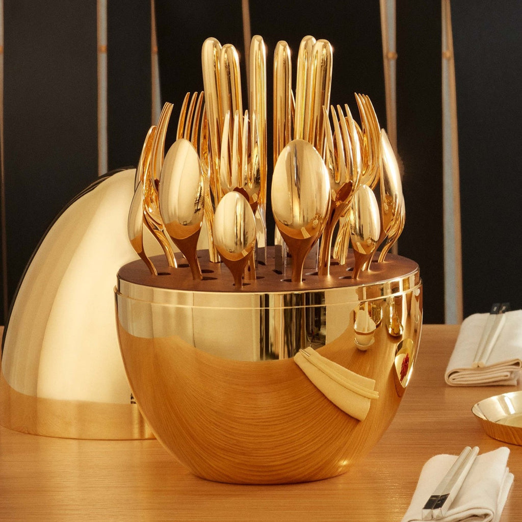 Golden spoons neatly placed within the elegant oval cutlery stand.