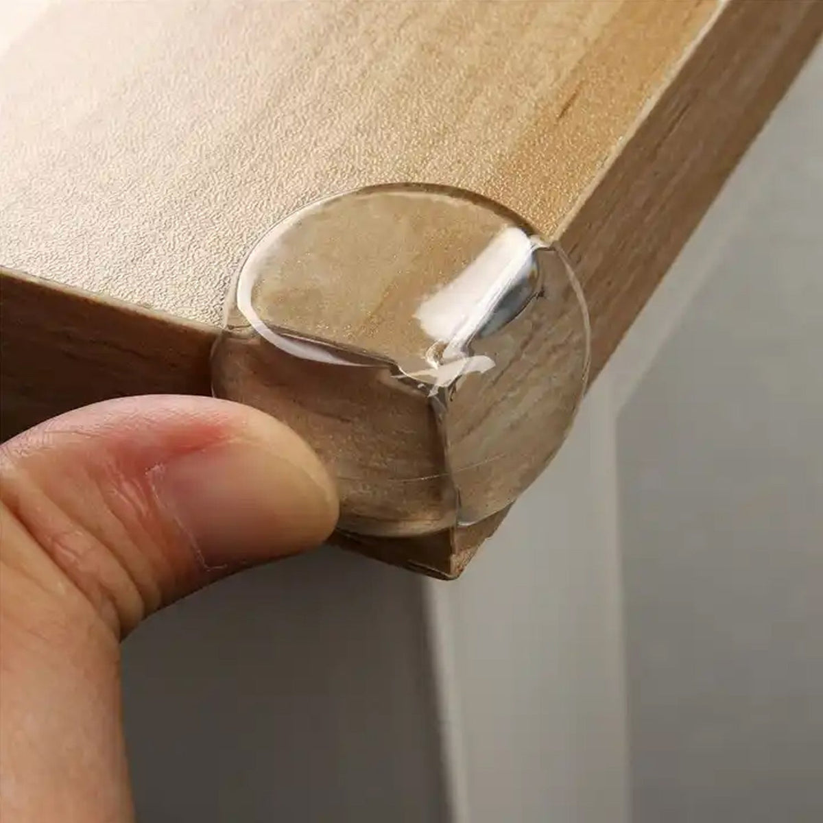 Clear baby corner protectors applied to a table edge for safety.