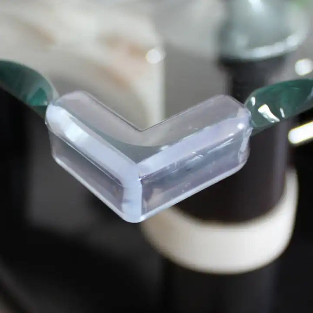 Transparent baby corner protectors (200 pc set) on a wooden table edge.
