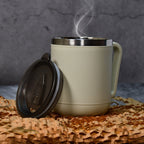 A sleek stainless steel coffee mug with an ergonomic handle.