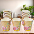 A stack of mixed design disposable paper cups ready for use at an Indian gathering.