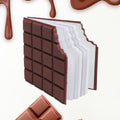 Closed chocolate scented diary with a bite-shape design on a white background.