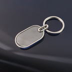 Compact oval metal keyring with black center and polished silver frame