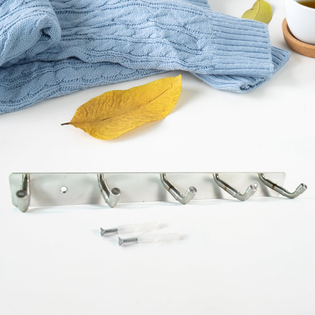 Polished stainless steel 5-hook rack holding towels and kitchen utensils
