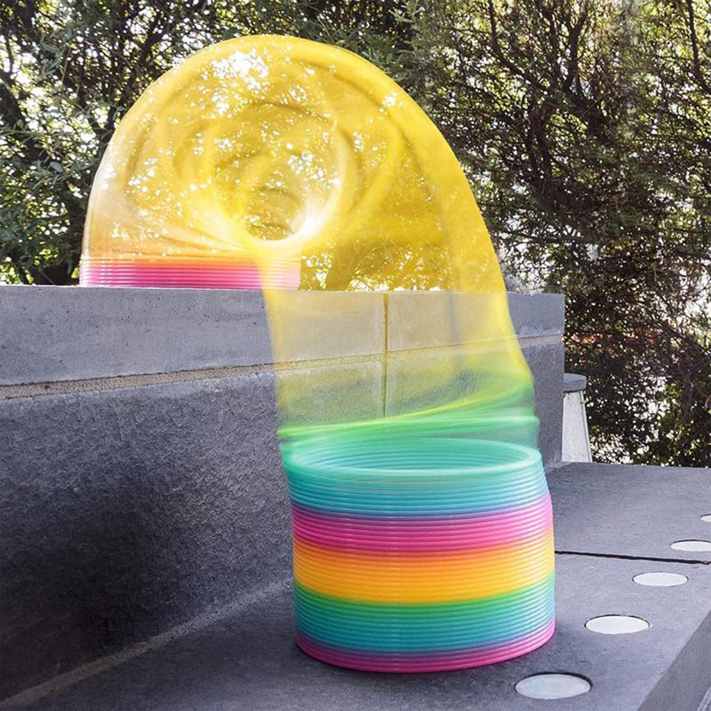 A Rainbow Slinky Toy gracefully moving down stairs, illustrating its classic spring action.