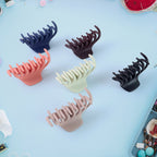 Multicolor hair claw clips arranged on white background showing size variety